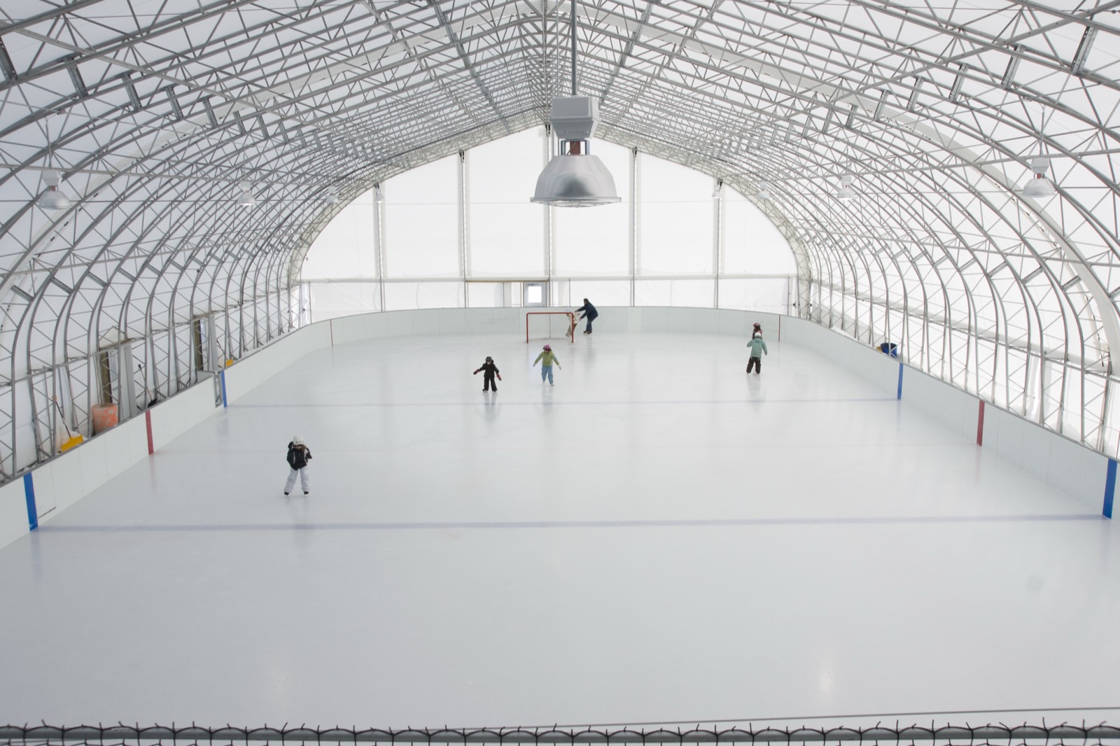 Community skating rink inside a fabric building with natural daylight
